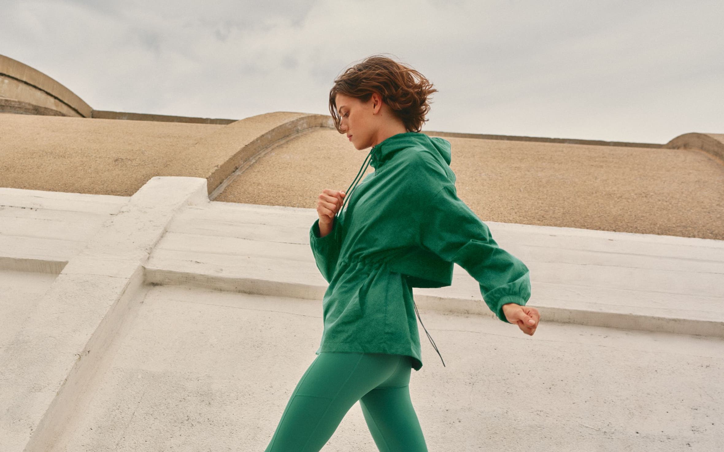 Woman wearing a Zella jacket and leggings with socks and adidas sneakers.