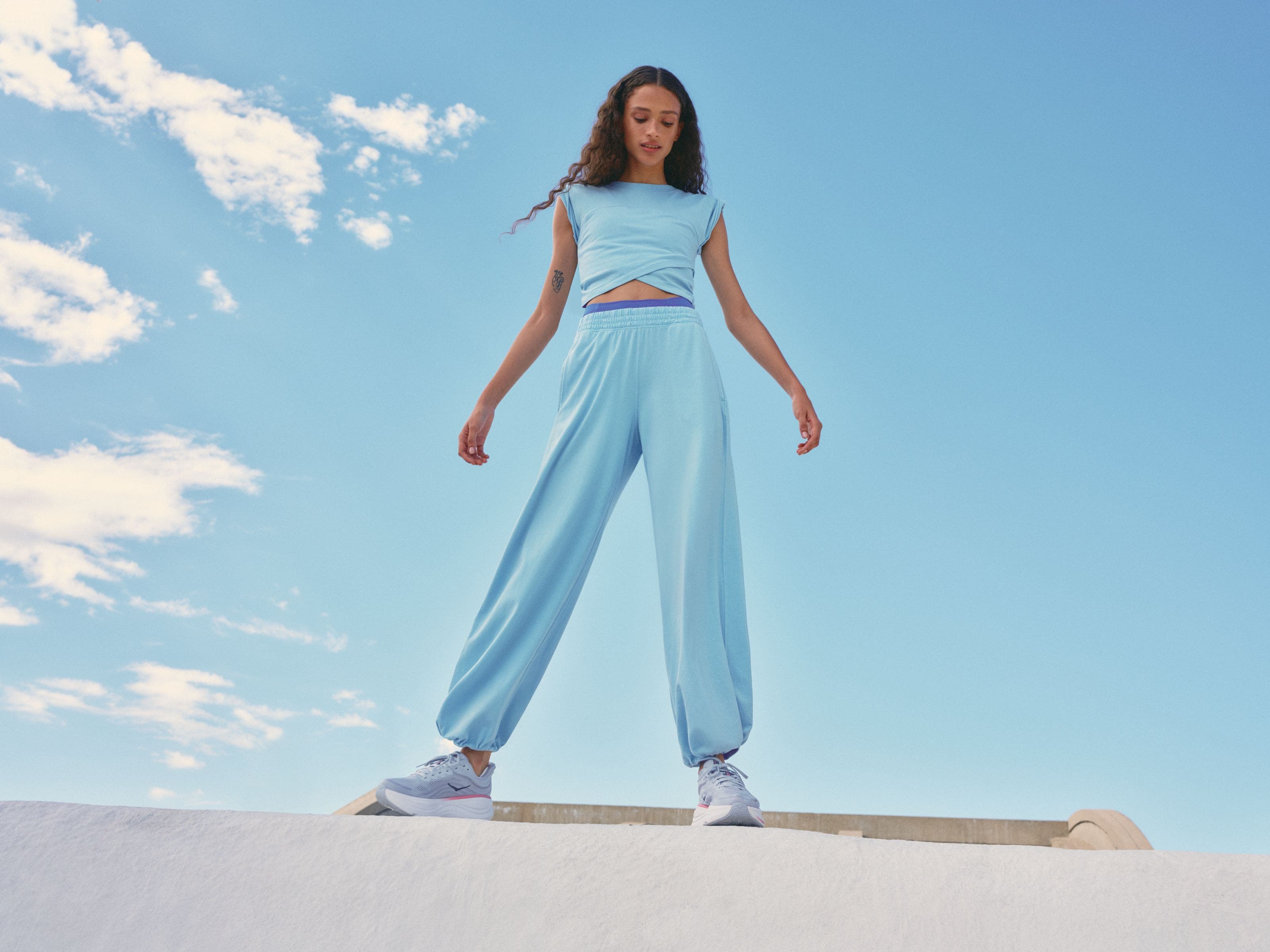 Woman wearing a light-blue active set and sneakers.