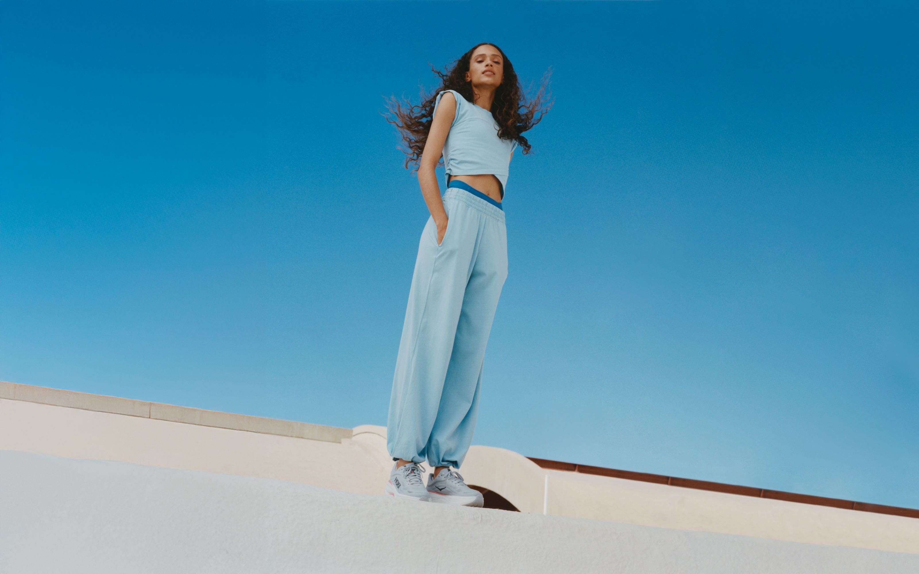 Woman wearing a Free People Movement active set and HOKA sneakers.