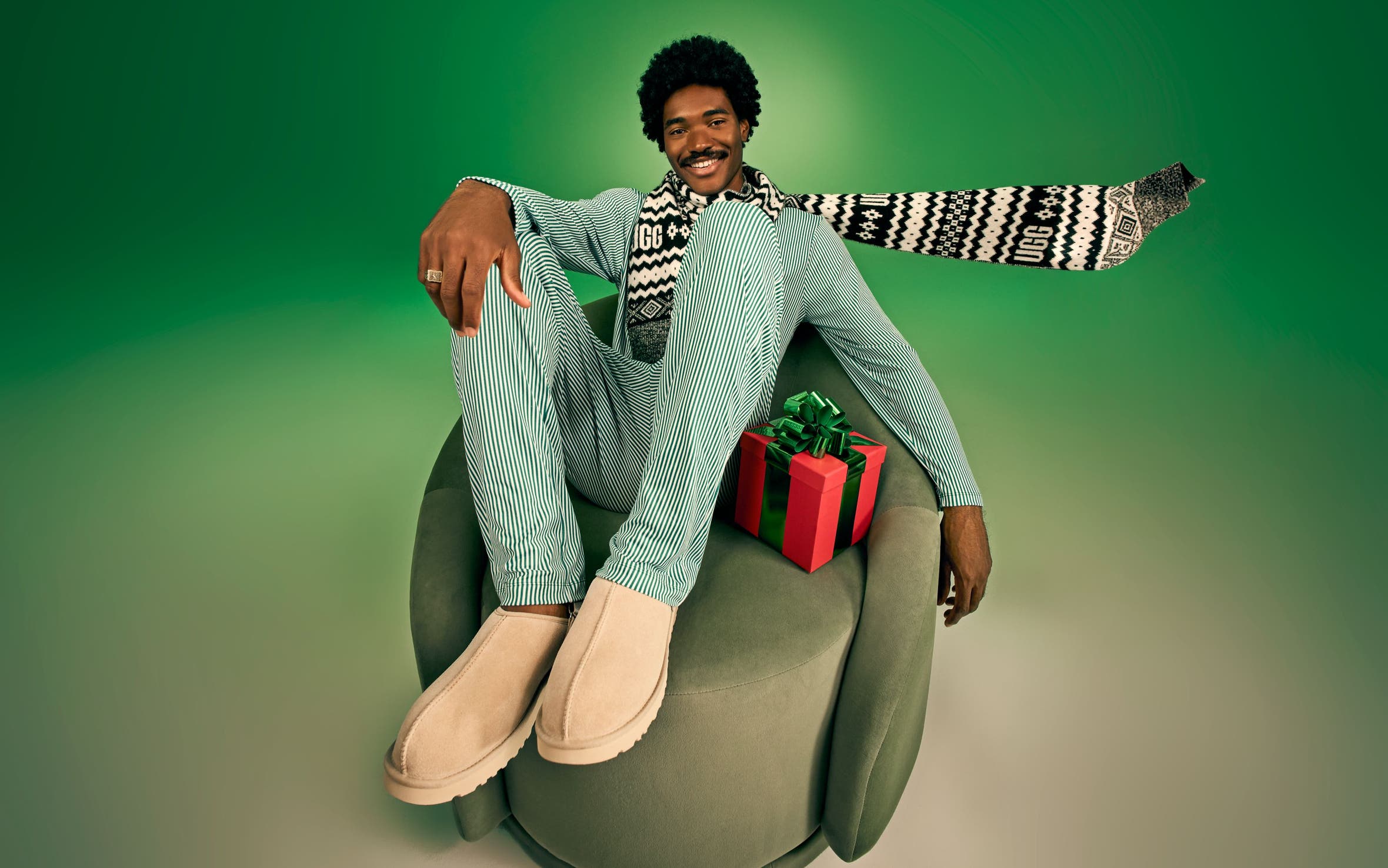 A man wearing pajamas with UGG slippers. 