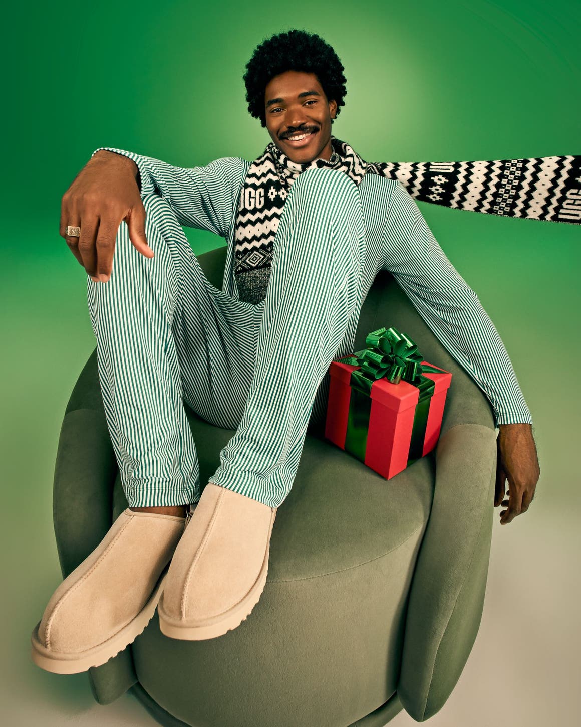 A man wearing pajamas with UGG slippers. 