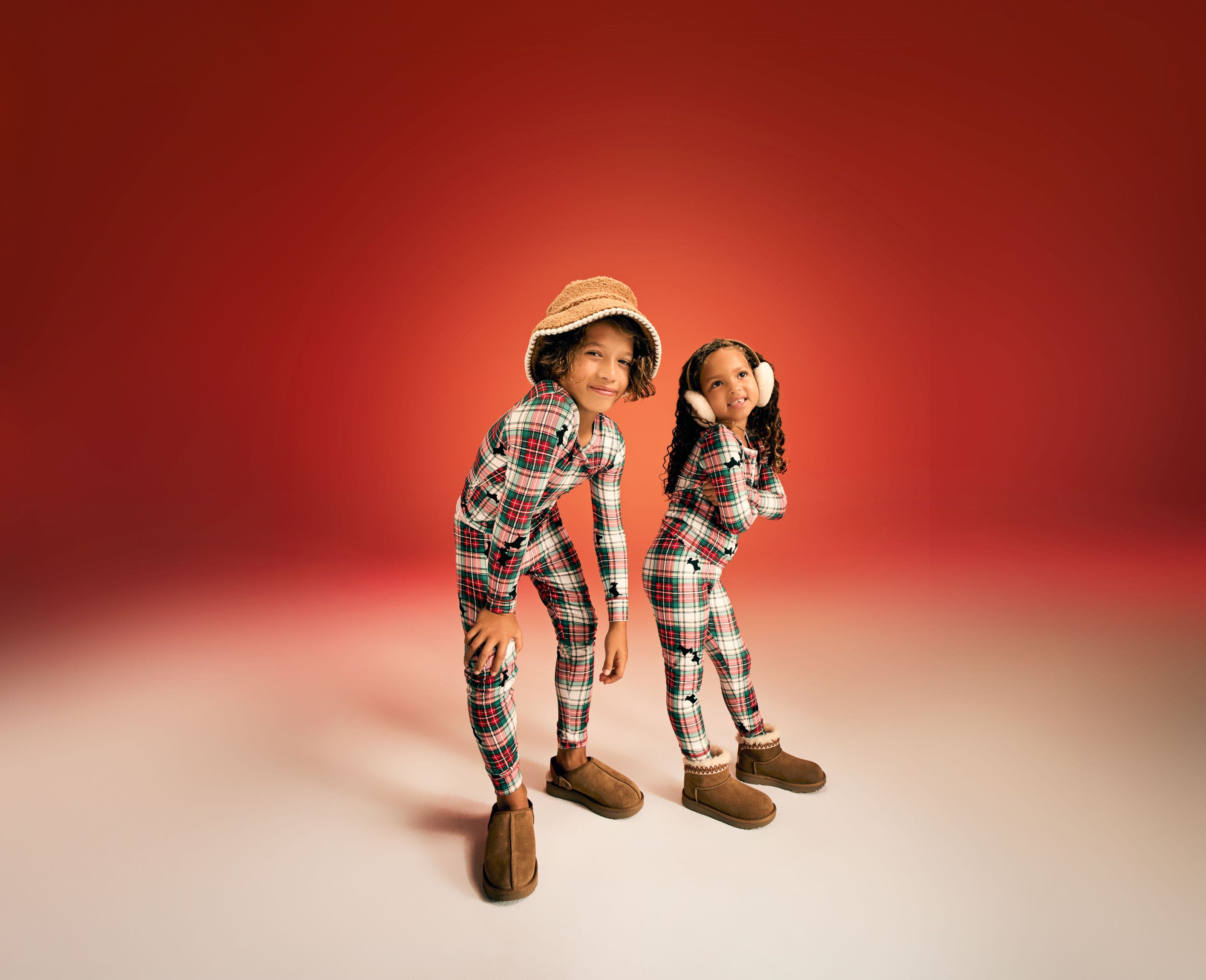 Two kids wearing matching pajamas.