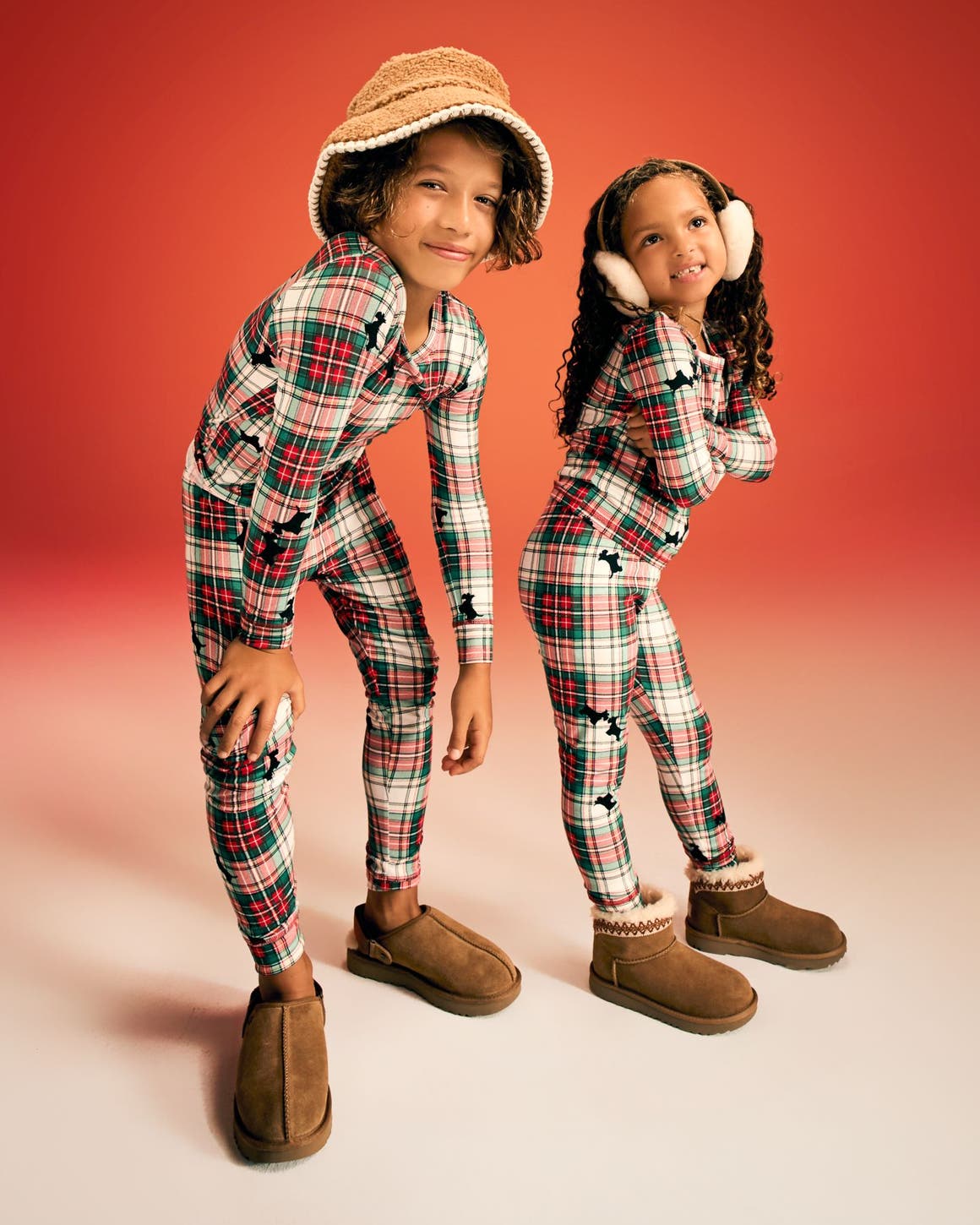 Two kids wearing matching pajamas.