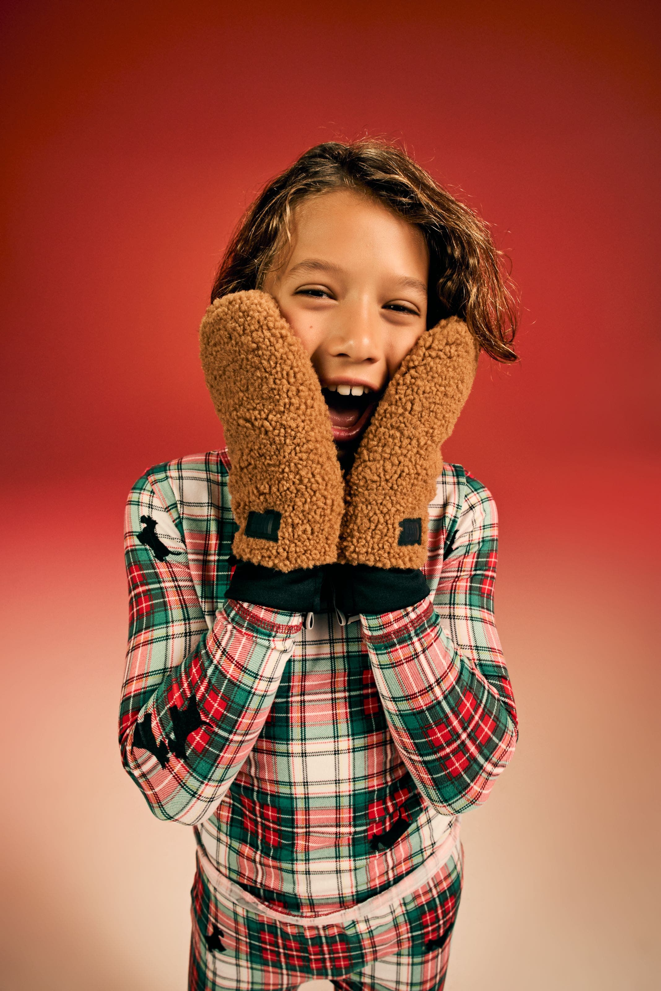 Child wearing gloves and pajama set.
