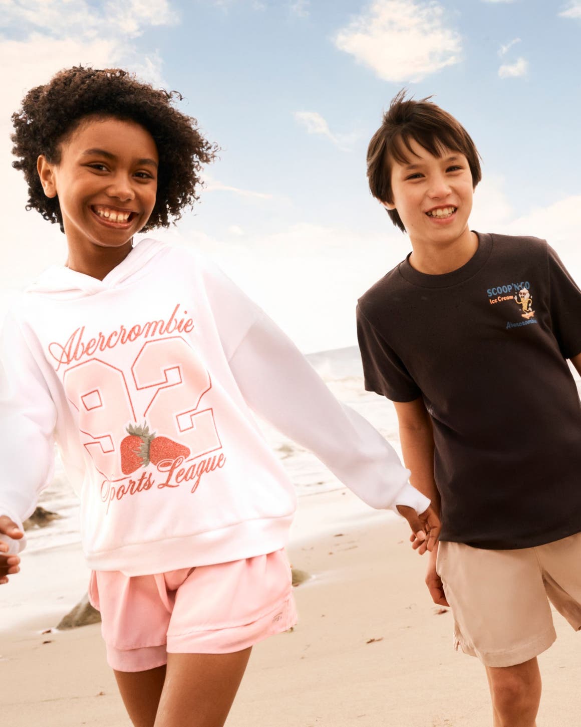 Two kids in Abercrombie shorts and T-shirts at the beach.