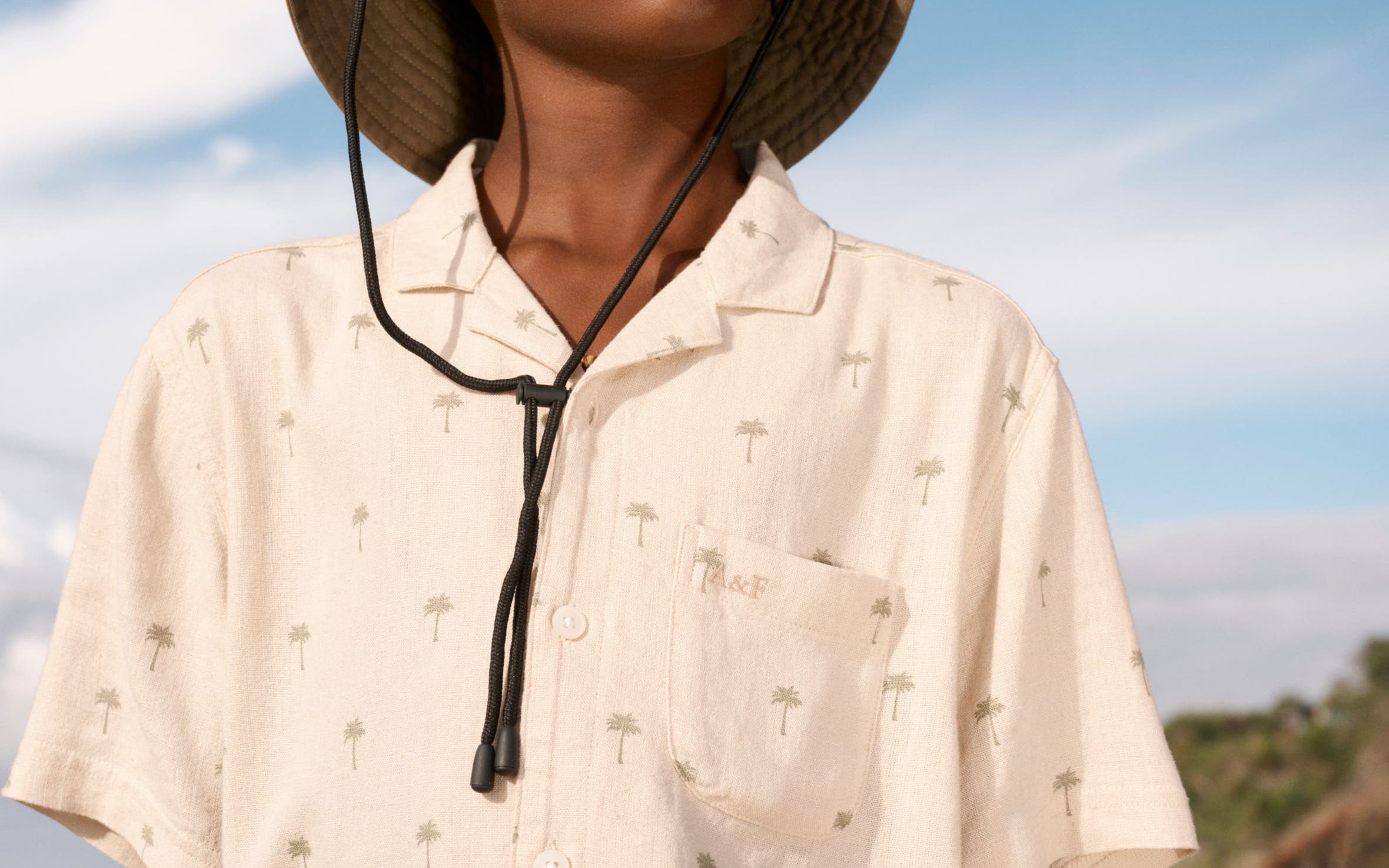 A boy wearing a palm tree-print camp shirt from Abercrombie Kids.
