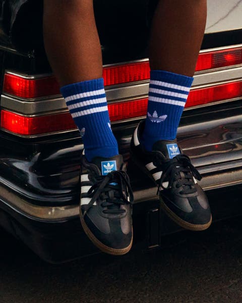 A person wearing adidas sneakers, part of Nordstrom's 125th celebration.