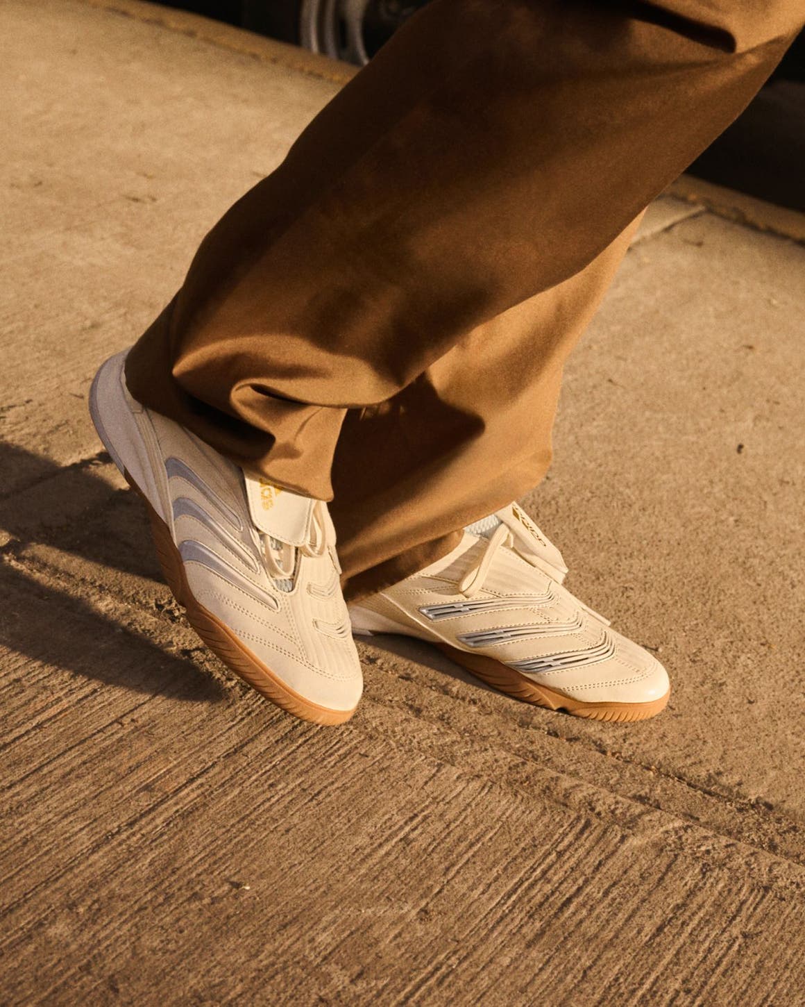 Person wearing adidas pants and sneakers, part of Nordstrom's 125th celebration.
