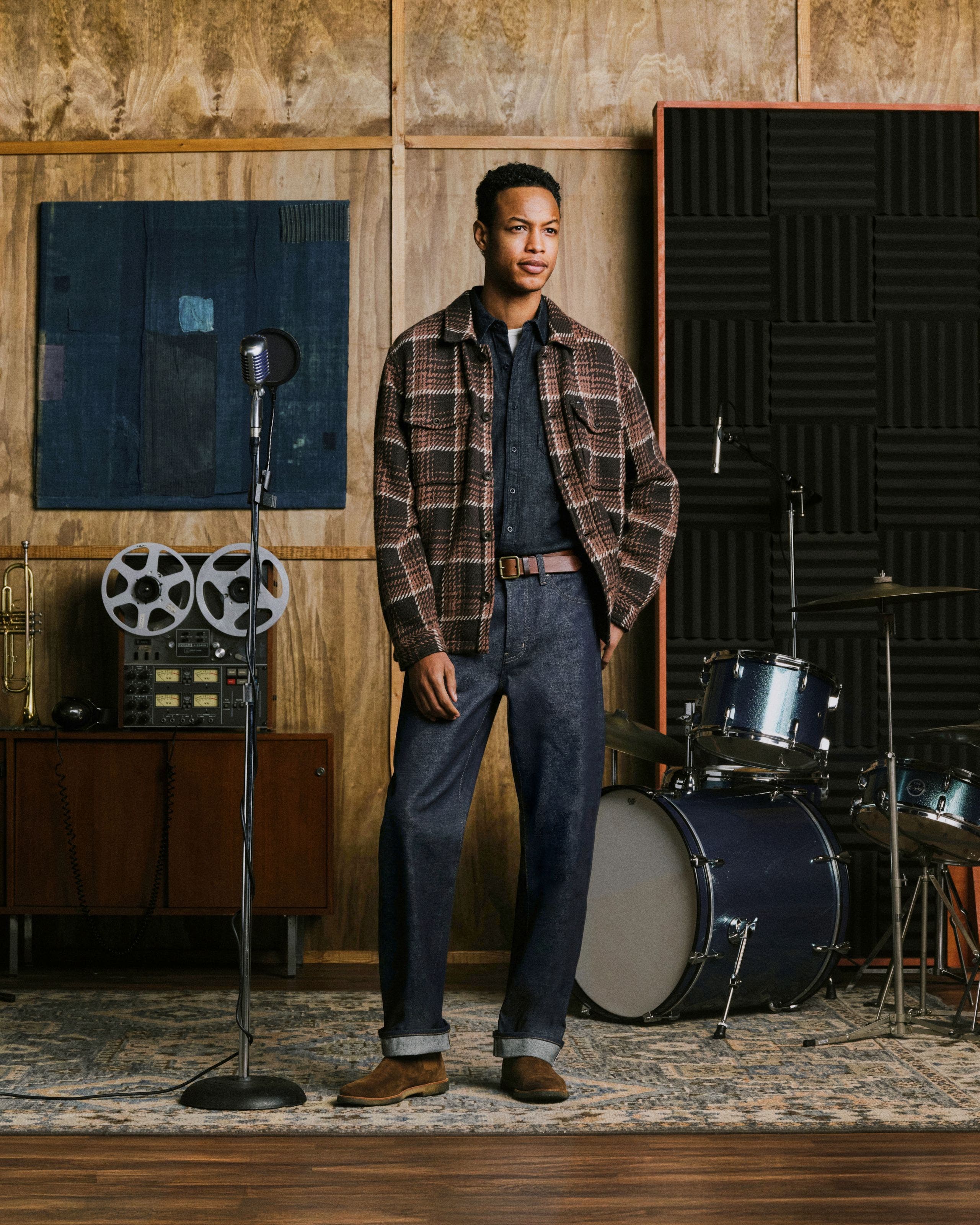 A man wearing flannel, shirt, and AG jeans.
