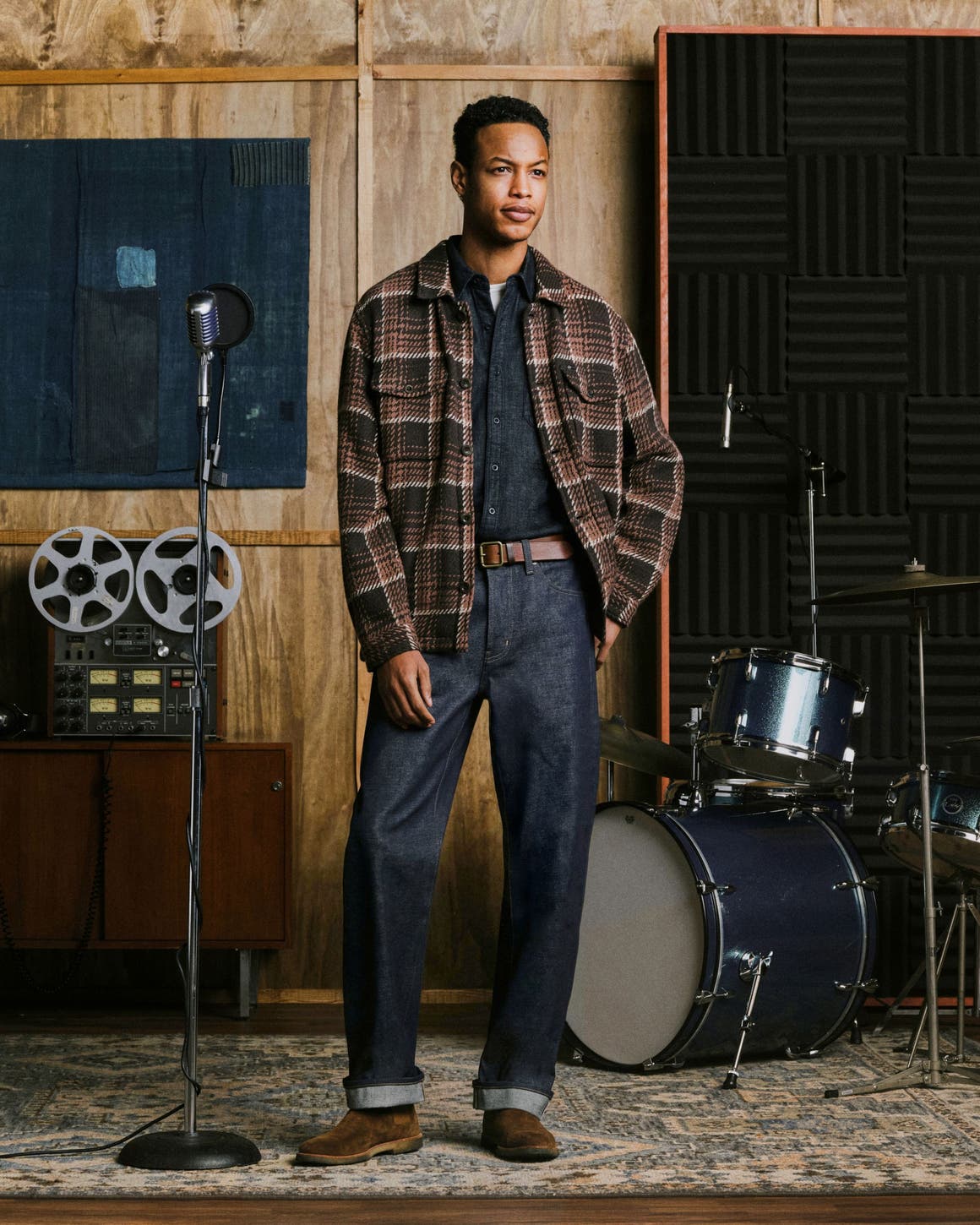 A man wearing flannel, shirt, and AG jeans.