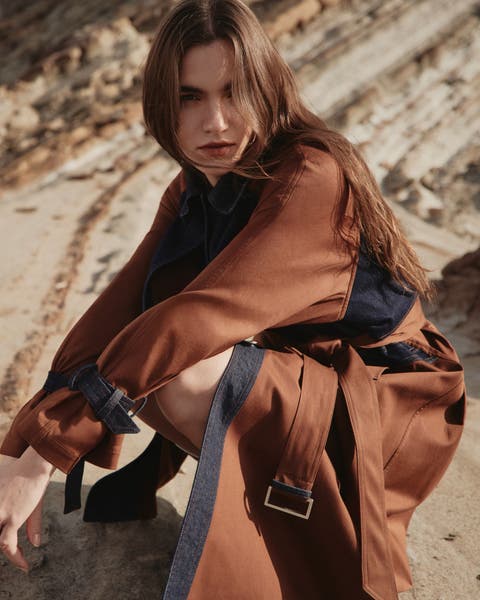 Woman wearing brown AllSaints silk trench coat.