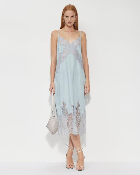 Woman wearing a blue lace Allsaints dress.