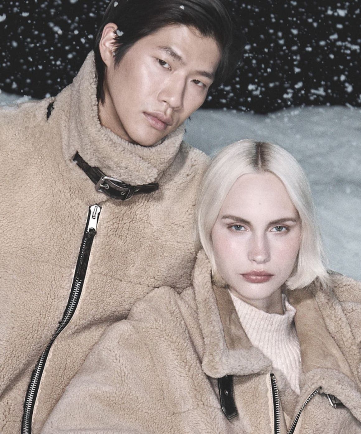 Man and woman wearing AllSaints coats.