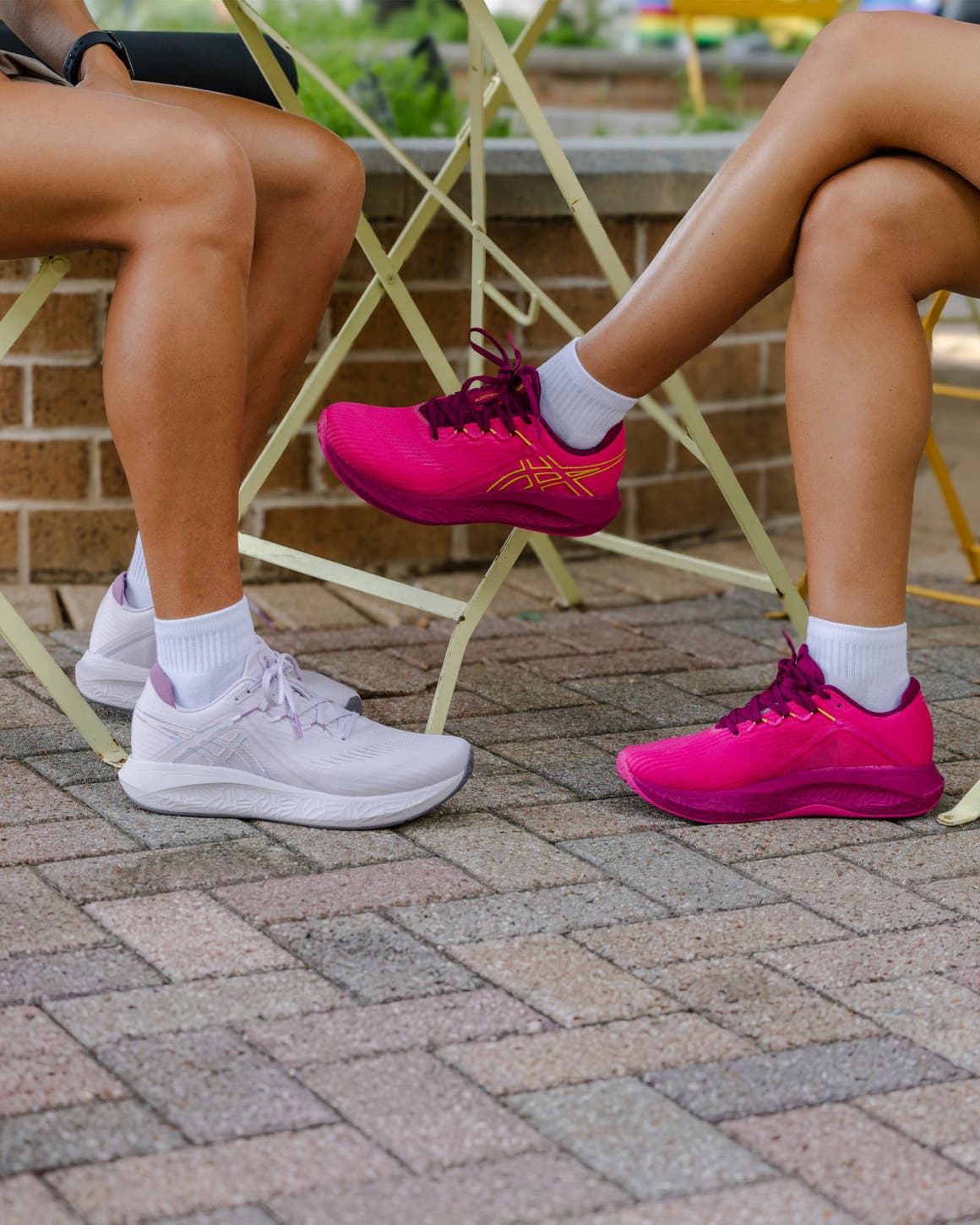 Two women wearing ASICS sneakers.