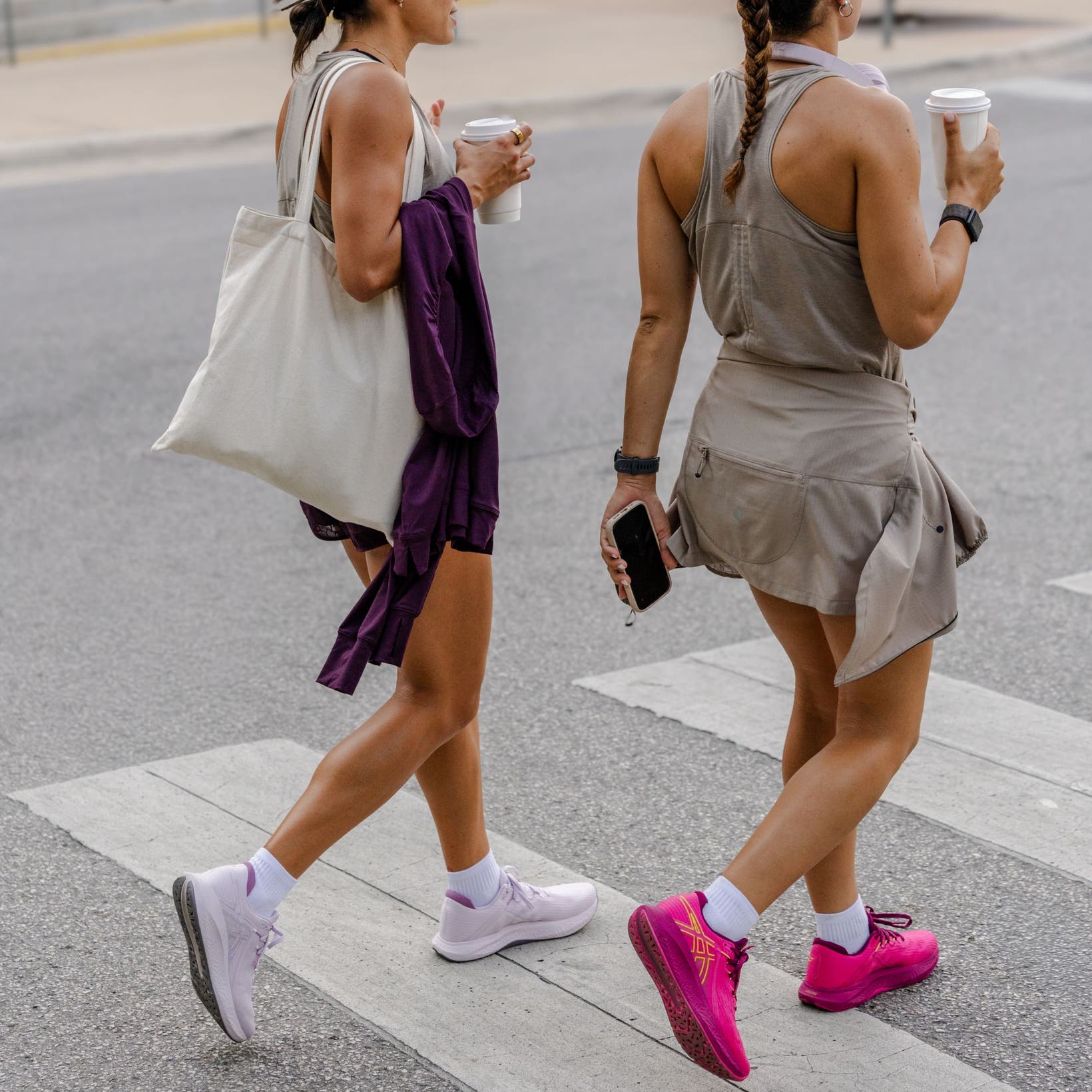 Two women wearing ASICS® sneakers.