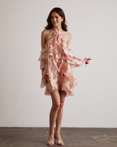 Woman wearing pink halter neck floral short dress.