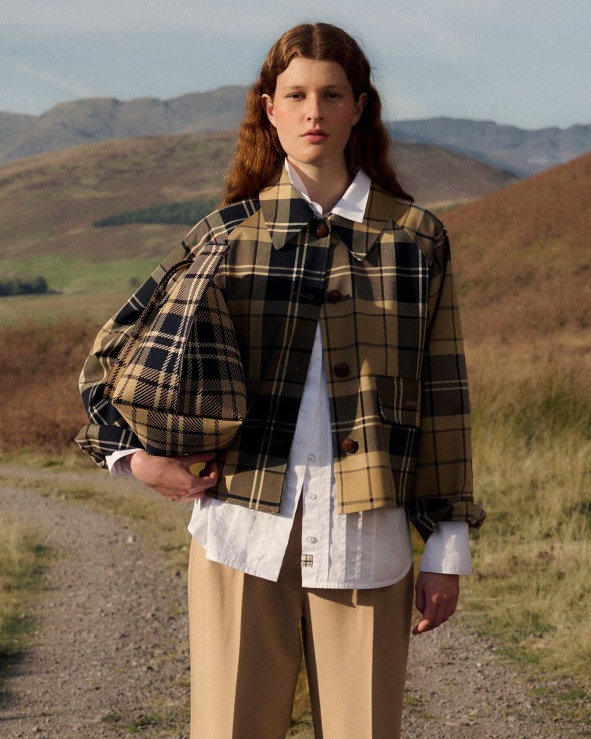 A woman wearing a tartan Barbour jacket.