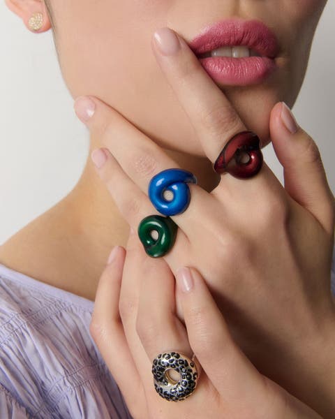 A woman wearing several colorful rings. 