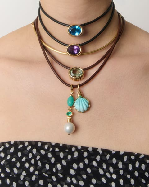 A woman wearing multiple colorful necklaces. 