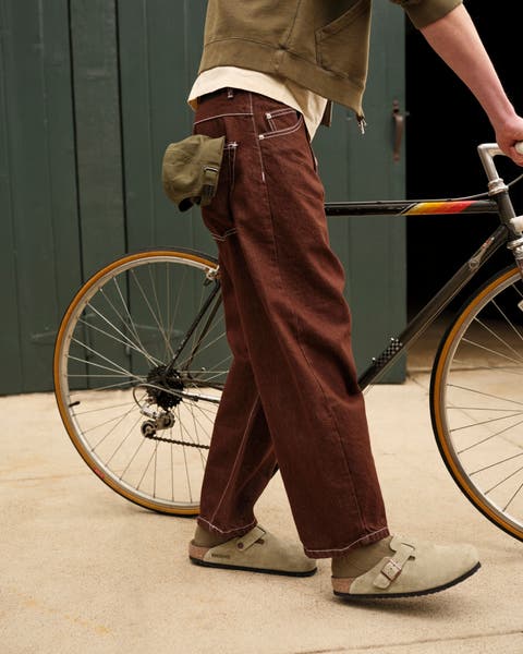 A man wearing Birkenstock shoes with jeans.