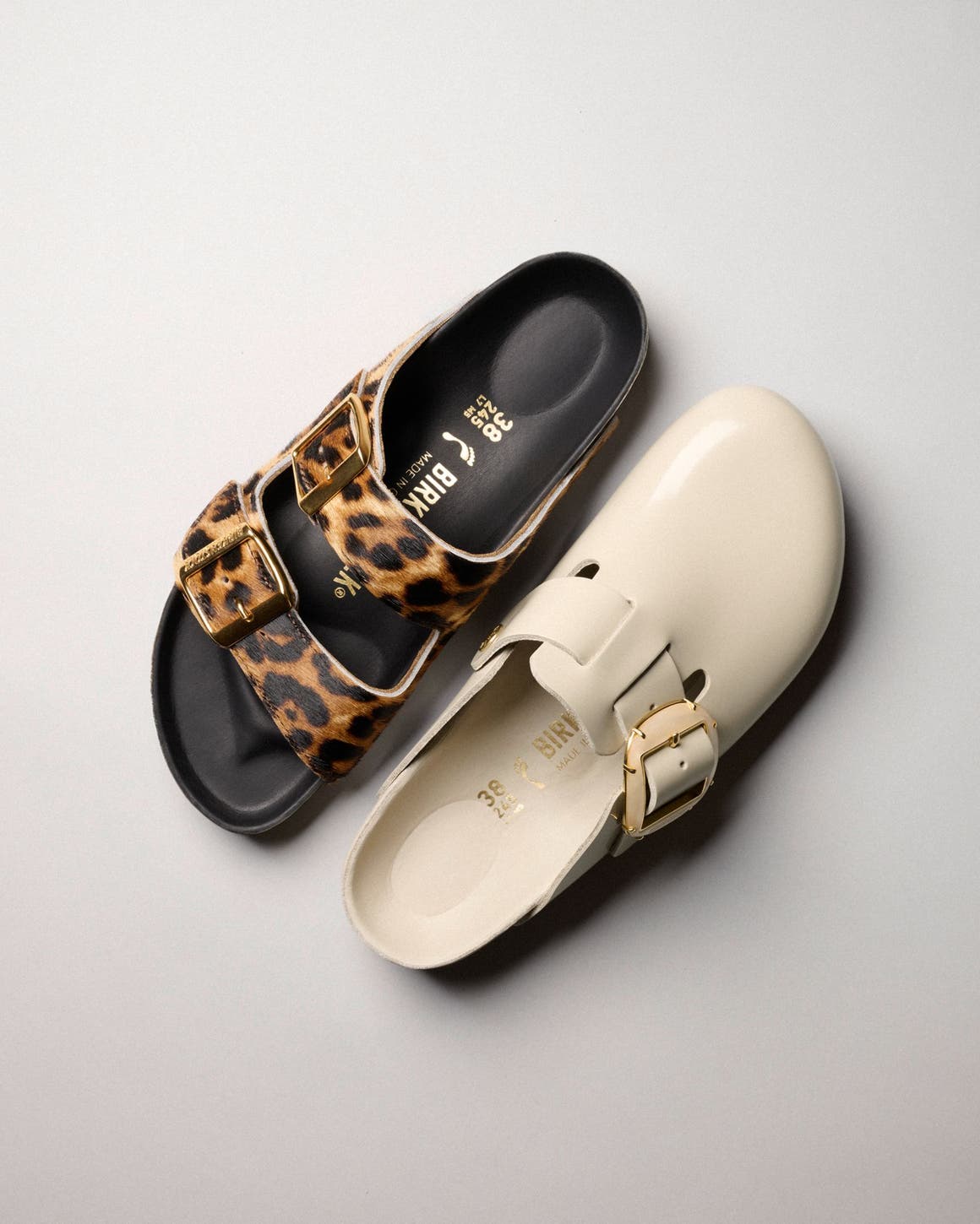 Birkenstock Arizona sandals in leopard pony hair and Boston clogs in pearl leather, flatlay.