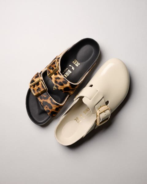 Birkenstock Arizona sandals in leopard pony hair and Boston clogs in pearl leather, overhead flatlay.