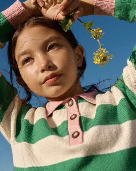 A girl wearing a green and white striped sweater.
