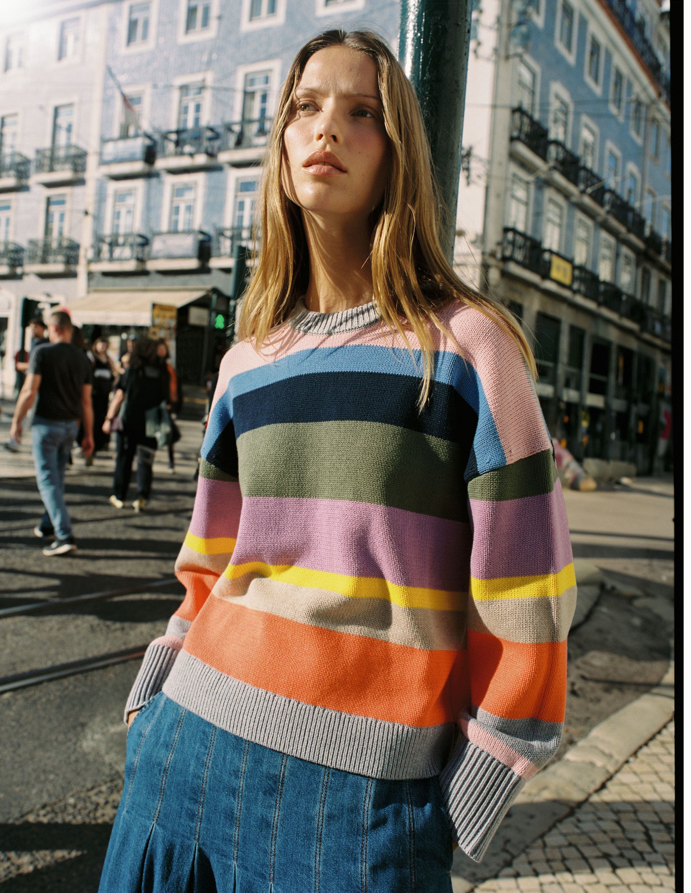 Woman wearing multi color striped sweater.