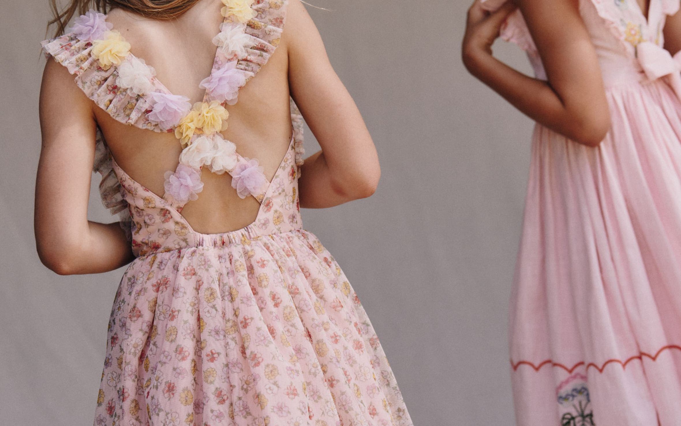 Two girls wearing pink spring dresses.