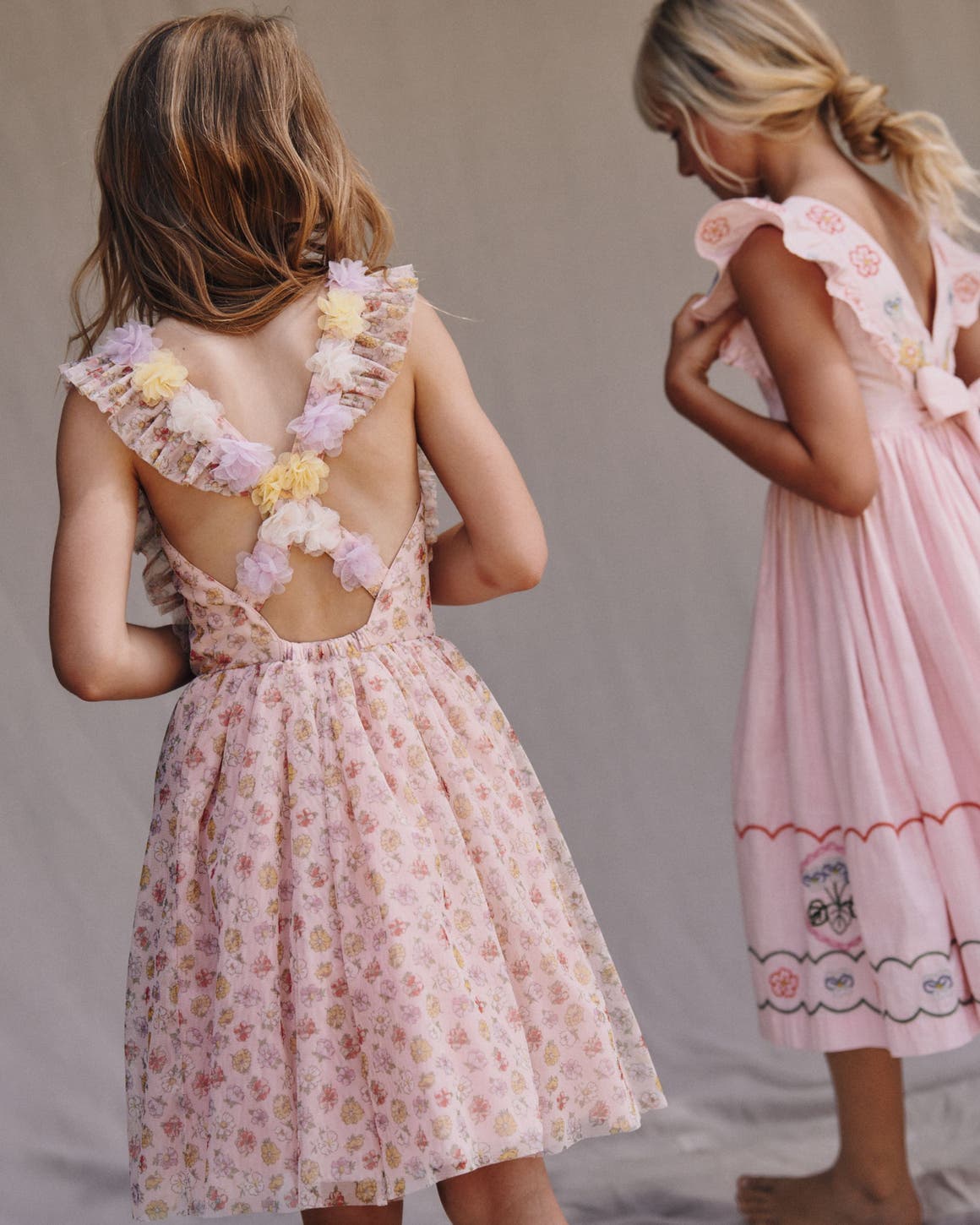 Two girls wearing pink spring dresses.