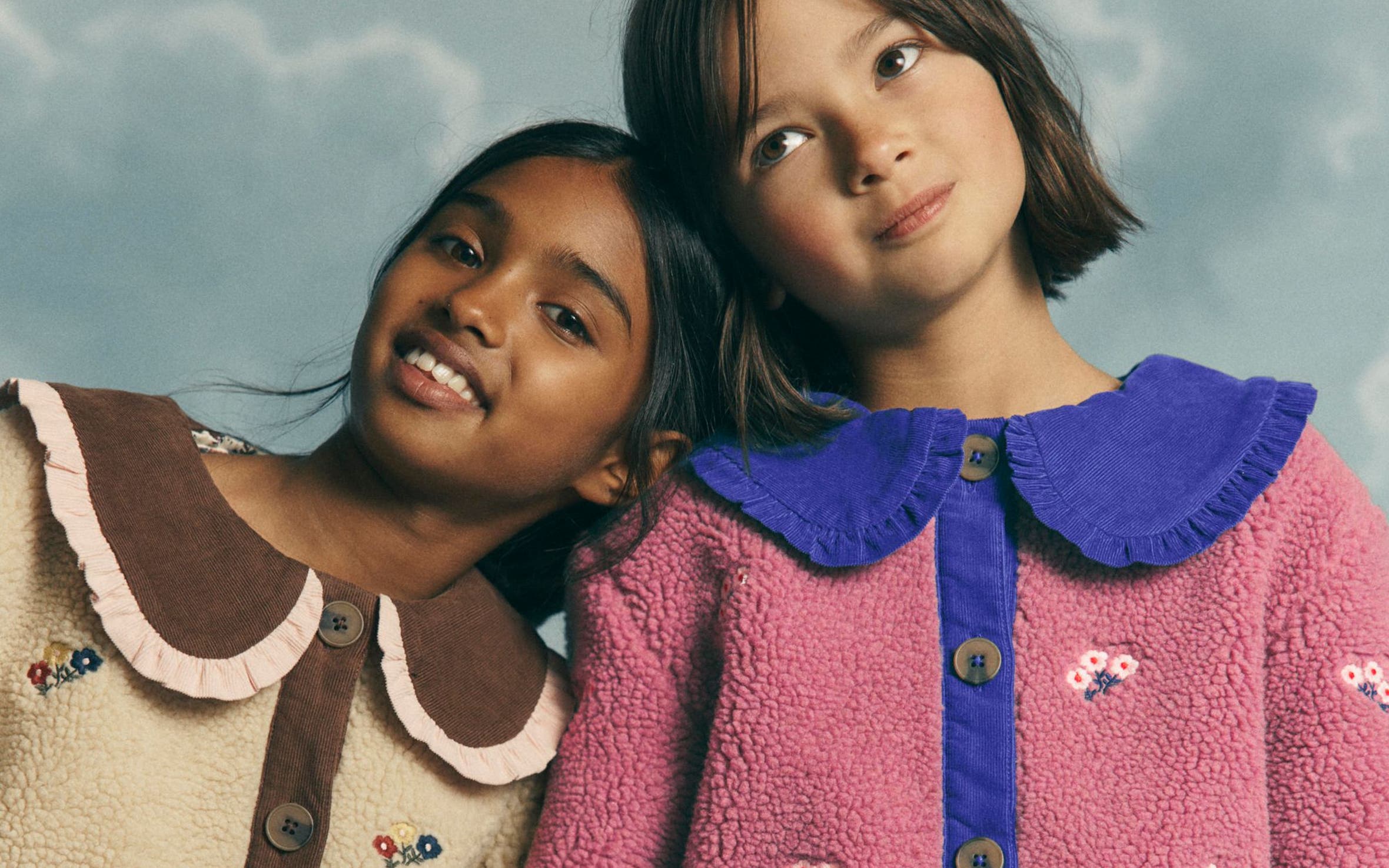 Two girls in Mini Boden sherpa fleece jackets.