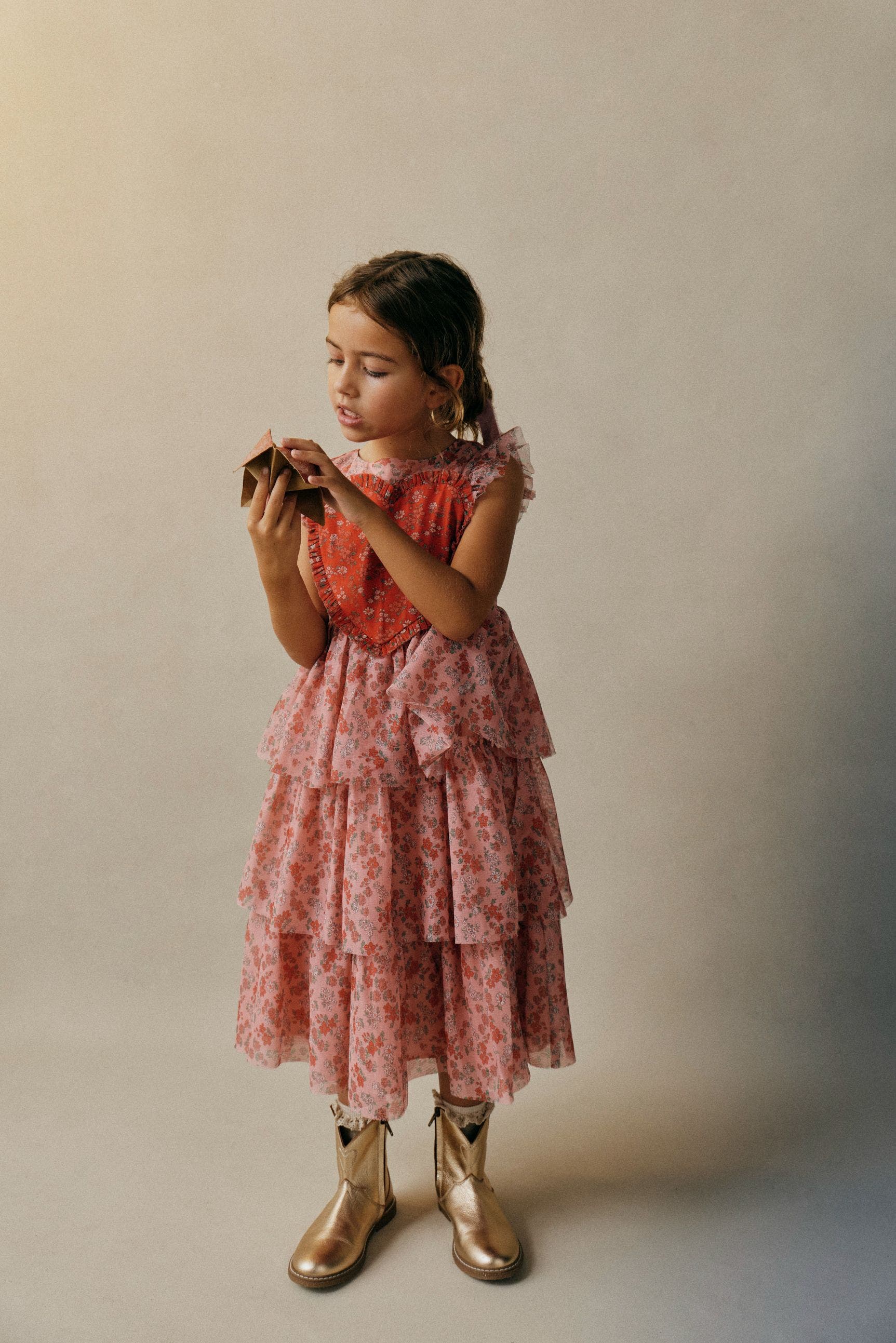 Girl wearing a pink tiered Mini Boden dress.