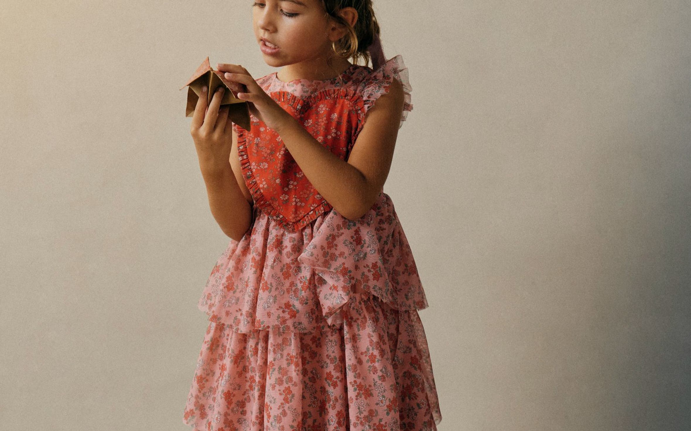 Girl wearing a pink tiered Mini Boden dress.