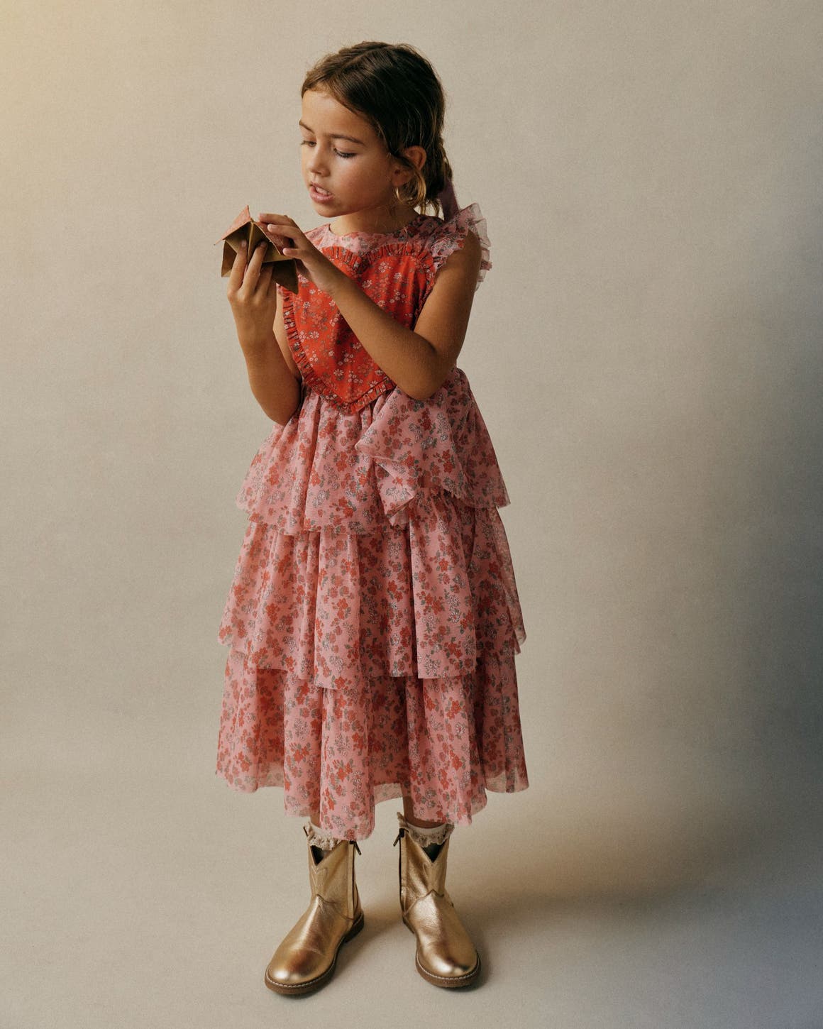 Girl wearing a pink tiered Mini Boden dress.