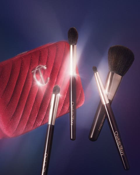 Featuring a red cosmetic bag and four cosmetic brushes from Charlotte Tilbury.