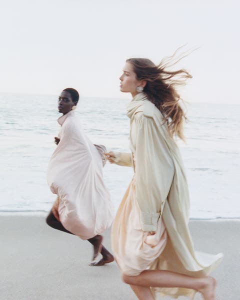 Two woman running on a beach wearing Chloé looks.