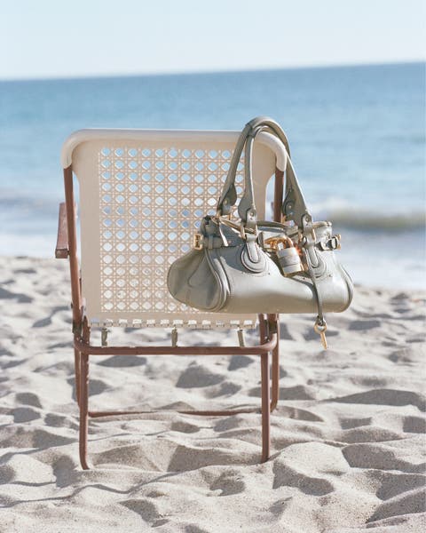Chloé handbag hanging on a chair at the beach.