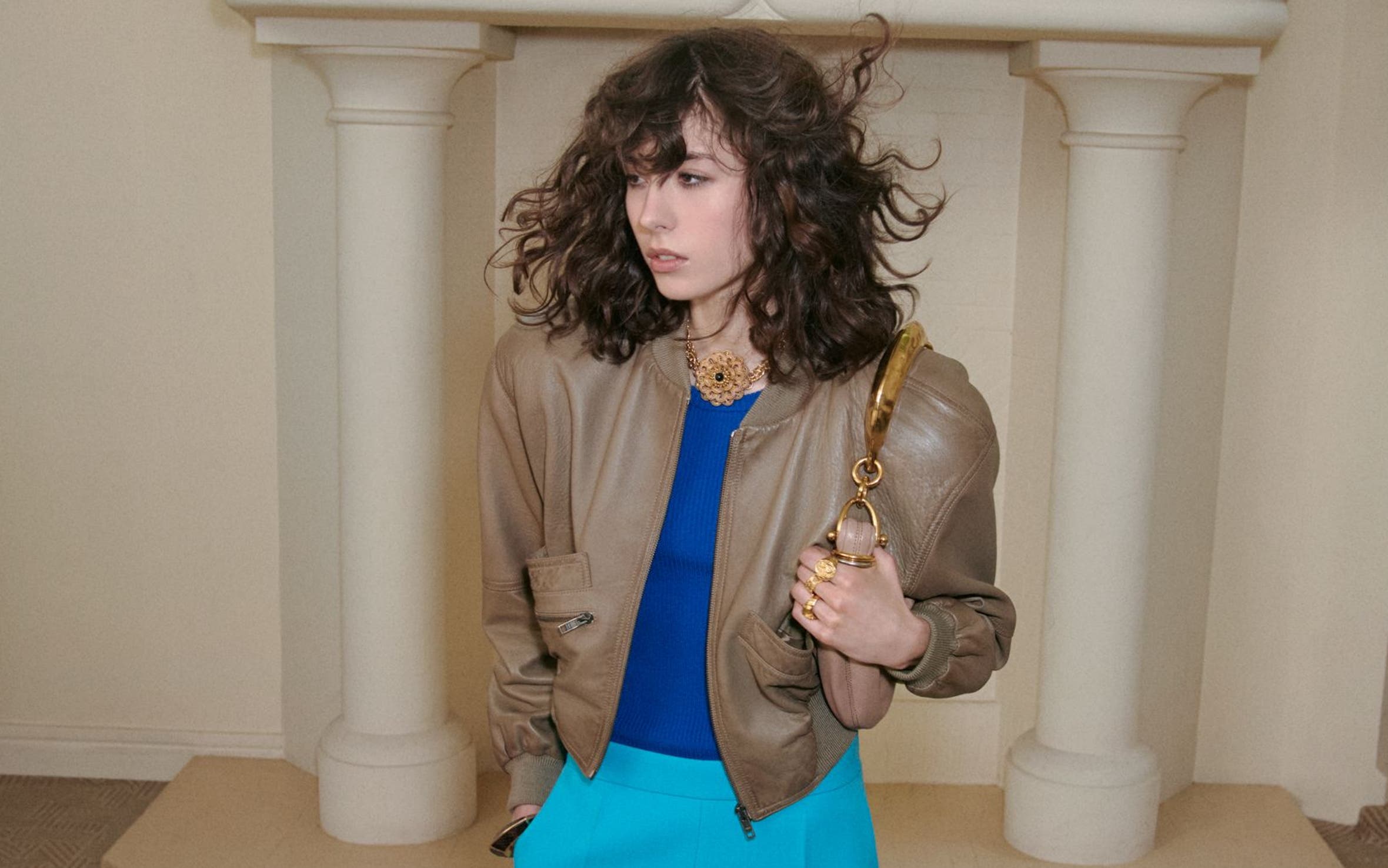 Woman wearing a leather jacket, top, pants, handbag and heels from Chloé.