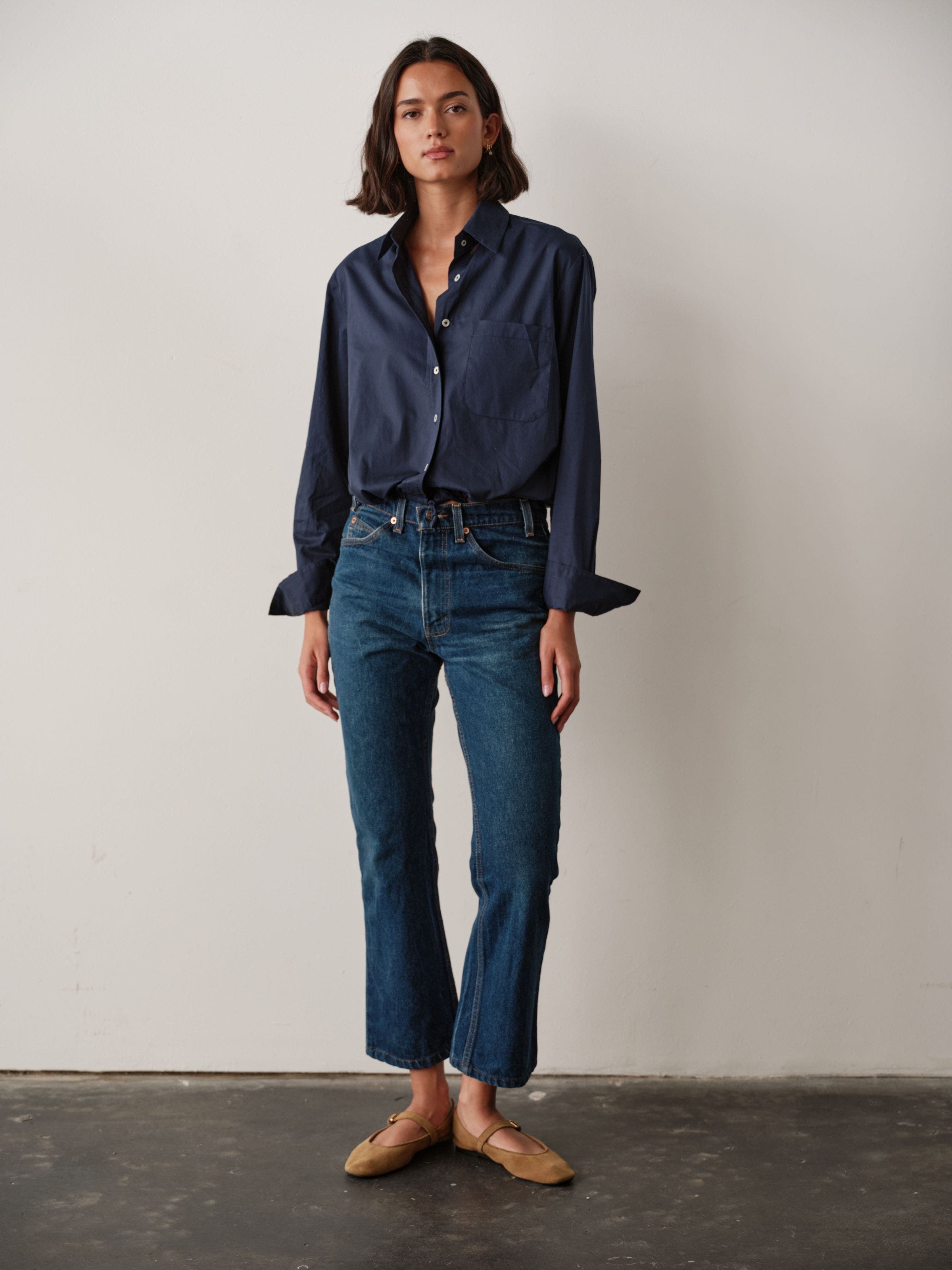 A woman wearing a navy blue button up.