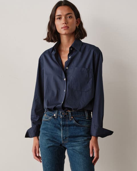 A woman wearing a navy blue button up.