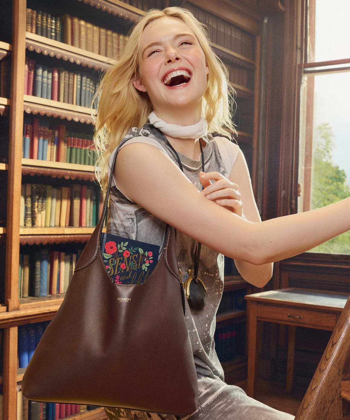 Elle Fanning carrying a coach bag.