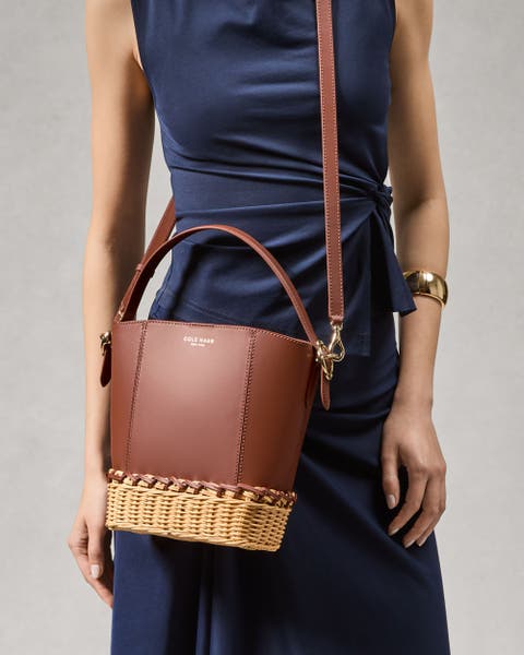 Woman wearing a brown Cole Haan shoulder bag.