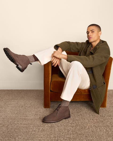 Man wearing jacket, white pants and Cole Haan boots