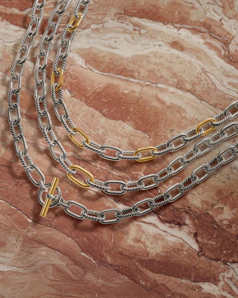 Three chain link silver and gold necklaces.