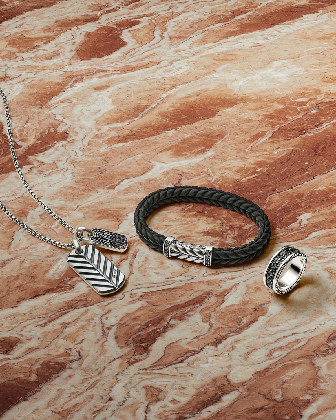 A silver pendant, braided leather bracelet and silver ring from David Yurman.