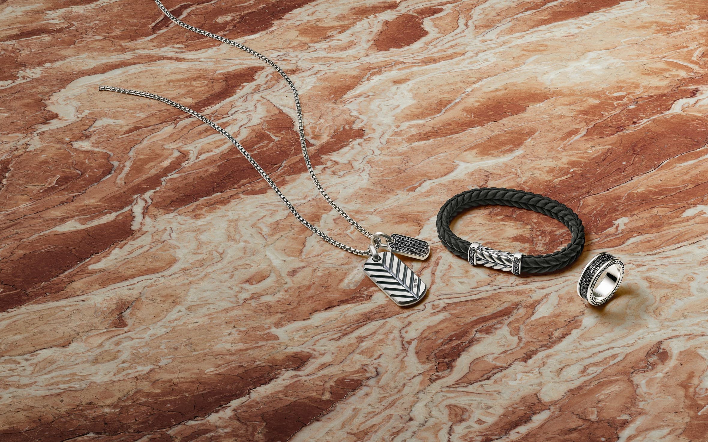 A silver pendant, braided leather bracelet and silver ring from David Yurman.