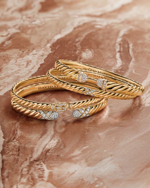 A stack of gold bracelets with diamond accents.