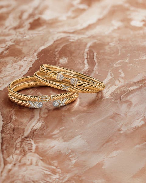 A stack of gold bracelets with diamond accents.