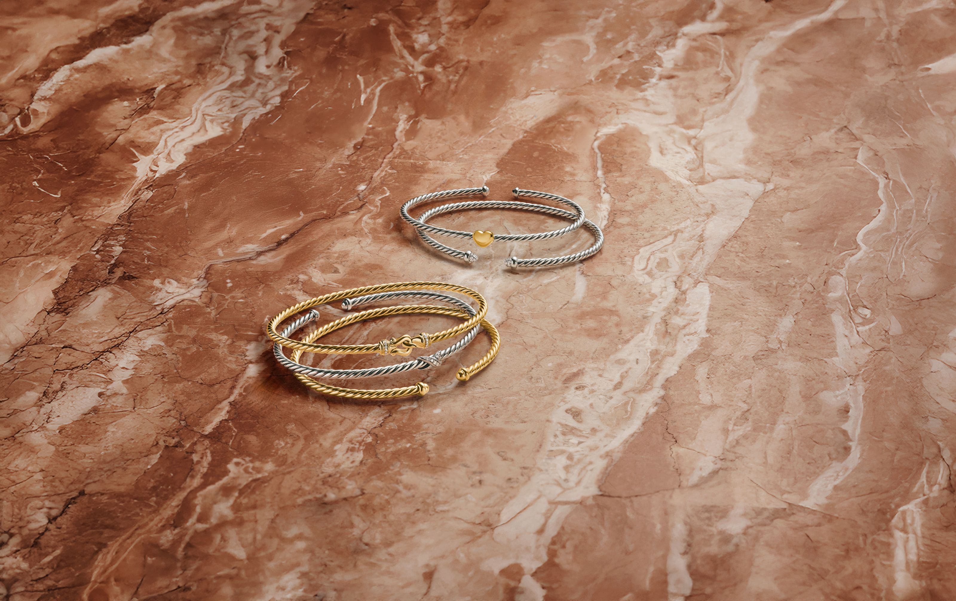 A stack of gold and silver bracelets.