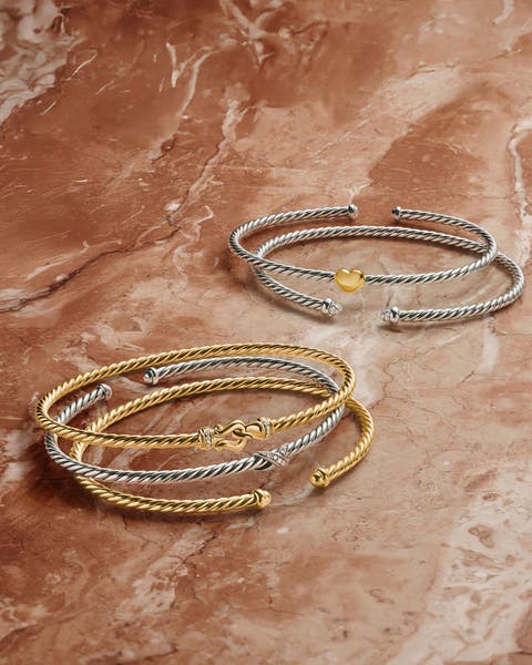 A stack of gold and silver bracelets.